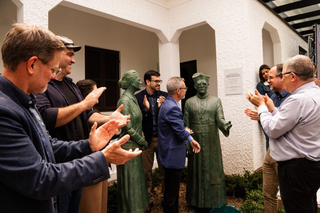 Público aplaude as esculturas de Lisbeth Suing e do padre Jorge Anneken no Memorial Anneken, em Rolante