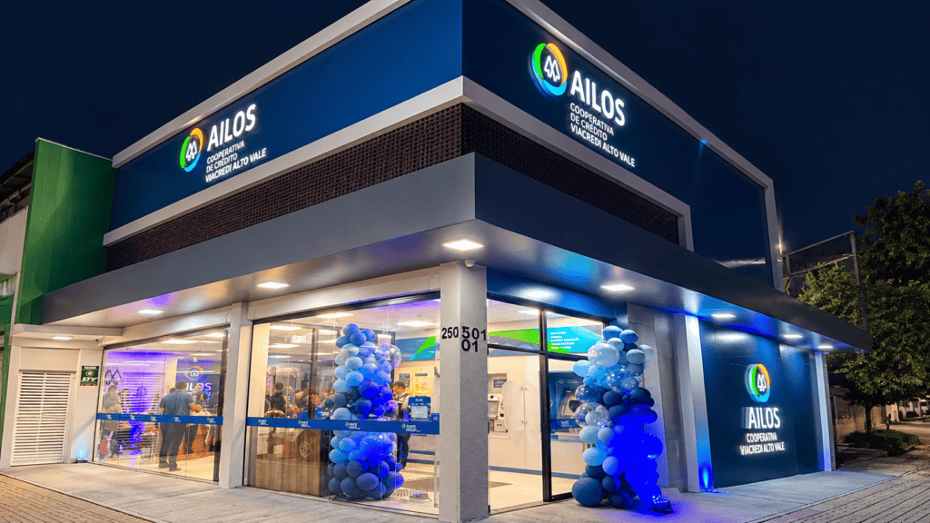Ailos Viacredi Alto Vale reinaugura posto em novo endereço em Novo Hamburgo Fachada iluminada da Ailos Viacredi Alto Vale à noite, em Novo Hamburgo