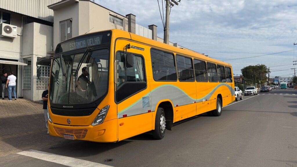 Ônibus amarelo e cinza da Expresso Presidente Getúlio estacionado na rua